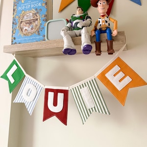 Handmade Custom Fabric Name Banner in Brick Red, Green, Mustard Yellow, Green and Blue Stripes with White Letters