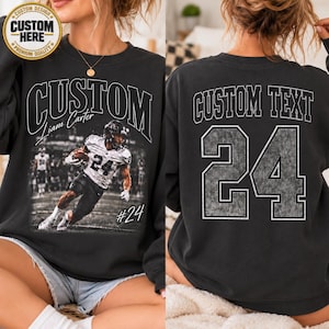 May include: A black crewneck sweatshirt featuring a front graphic of a football player in a white jersey with the text CUSTOM and Liam Carter. The back displays the text CUSTOM TEXT above the large number 24 in a distressed grey font style.
