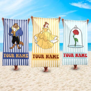 May include: Three beach towels with vertical stripes and character designs. One towel features Beast, another Belle, and the third a rose in a glass dome. Each towel has the text "YOUR NAME" at the bottom.