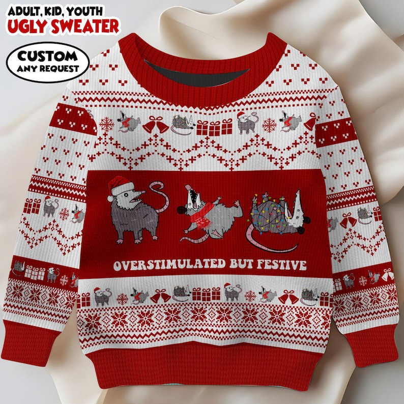 Op de afbeelding: Een rode en witte lelijke kersttrui met een feestelijk opossum-ontwerp. De trui heeft de tekst "OVERSTIMULATED BUT FESTIVE" en "ADULT, KID, YOUTH UGLY SWEATER". Het ontwerp bevat opossums, cadeaus en sneeuwvlokken.