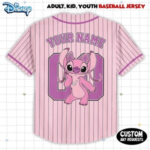May include: Pink baseball jersey with vertical pinstripes and the Disney logo. The back features the text "YOUR NAME" above a purple number 0 and a pink cartoon character. The jersey includes the text "ADULT, KID, YOUTH BASEBALL JERSEY".