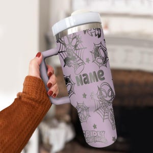 Puede incluir: Un vaso de color lavanda con asa, con dise&ntilde;os de Spidey y telara&ntilde;as. El vaso tiene la palabra "Name" impresa, junto con el texto "Spidey Amazing Friends".