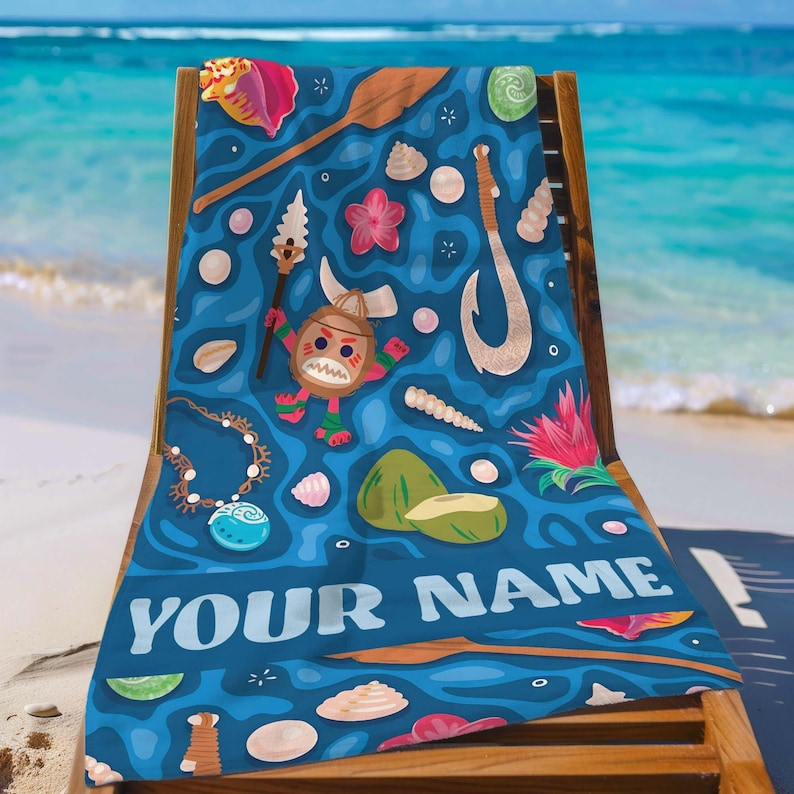 Pode incluir: Uma toalha de praia azul com um design de tema polin&eacute;sio com personagens de desenhos animados, conchas e um anzol. A toalha tem o texto "YOUR NAME" em branco. A toalha est&aacute; sobre uma cadeira de praia de madeira.
