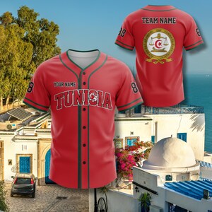 K&ouml;nnte beinhalten: Rotes Baseball-Trikot mit dem Wort "TUNISIA" in wei&szlig;en Blockbuchstaben auf der Brust. Das Trikot hat gr&uuml;ne Verzierungen und die Nummer 8 auf den &Auml;rmeln. Auf der R&uuml;ckseite des Trikots befinden sich ein Teamlogo und die Worte "TEAM NAME".