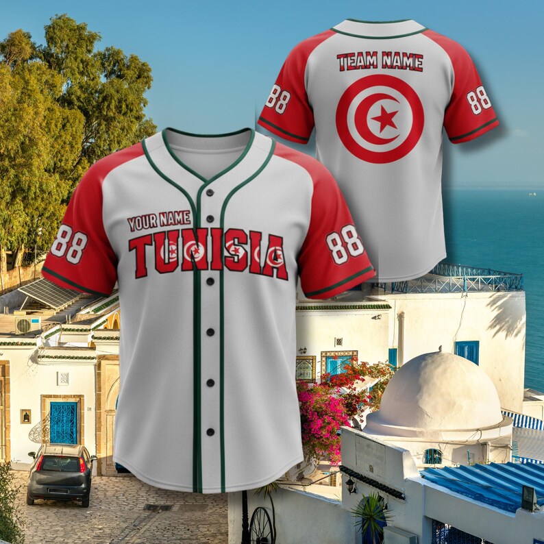 K&ouml;nnte beinhalten: Wei&szlig;-rotes Baseball-Trikot mit dem Wort "TUNISIA" in Rot und der Nummer "88" auf den &Auml;rmeln. Das Trikot hat eine gr&uuml;ne Paspelierung und den Text "YOUR NAME" &uuml;ber dem Wort "TUNISIA". Die R&uuml;ckseite des Trikots hat einen roten Kreis mit einem Stern.