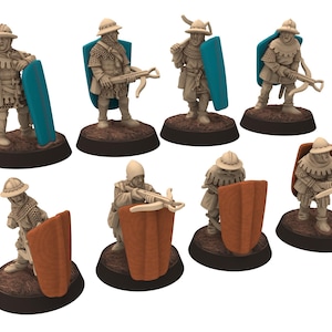 Puede incluir: Un conjunto de figuras en miniatura que representan soldados medievales. Cada figura viste ropa de época y porta armas y escudos. Los escudos son turquesa o marrón, y las figuras están sobre bases marrones oscuras.