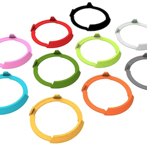 May include: A selection of ten brightly coloured, circular objects. Each ring is a different colour, including pink, red, black, white, green, grey, blue, yellow, and orange. The objects have a similar design with a curved shape and three small protrusions.