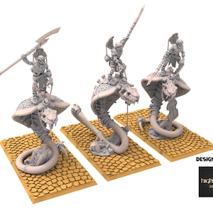 Op de afbeelding: Drie miniatuur fantasyfiguren. Elke figuur toont een skeletkrijger die op een cobra-achtig wezen rijdt. De cobra's zijn opgerold op getextureerde bases. De krijgers zijn bewapend met wapens. De afbeelding staat tegen een witte achtergrond.