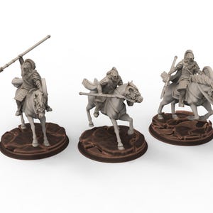 Könnte beinhalten: Drei Miniaturfiguren von Rittern in Rüstung auf Pferden. Jeder Ritter hält eine Waffe, wie einen Speer oder ein Schwert, und sitzt auf einem Pferd. Die Figuren sind grau und stehen auf braunen, strukturierten Sockeln.