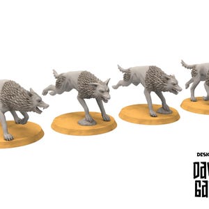 Peut inclure: Quatre figurines de loups gris dans des poses dynamiques, chacune sur une base ovale beige. Les loups ont des fourrures détaillées et sont dans diverses étapes de mouvement. Le texte "DESIGNED BY DAVALE GAMES" est en bas à droite.