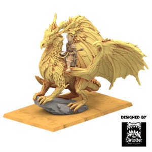 Peut inclure: Miniature dorée d'un dragon avec un cavalier, perché sur un rocher gris sur une base rectangulaire beige. Le dragon a de grandes ailes détaillées et un aspect de plumes. Le cavalier porte une armure. La base porte le texte "DESIGNED BY" et un logo.