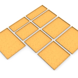 May include: An assortment of rectangular and square gold-colored trays arranged on a white background. The trays vary in size, with a textured surface and a thin, raised border. The arrangement suggests a display or storage solution.