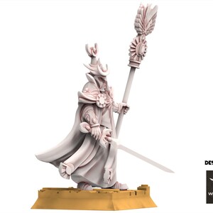 Op de afbeelding: 3D-geprinte figuur van een gekleed figuur met een staf en zwaard. De figuur draagt een hoed en cape, met gedetailleerde kleding en accessoires. De basis is lichtbruin. De tekst "DESIGNED BY" en een logo zijn zichtbaar.