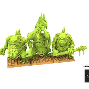 Op de afbeelding: Drie groene fantasie miniaturen van trollachtige wezens. Elke figuur heeft een unieke pose en houdt een wapen of object vast. De figuren staan op een bruine, getextureerde basis. De afbeelding bevat de tekst "DESIGNED BY" en het Highlands Miniatures logo.