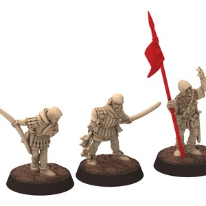 May include: Three miniature figurines of medieval soldiers. The figures are in various poses, one with a bow, one with a sword, and one holding a red flag. Each figure is on a brown base. The figures are beige in colour.