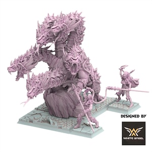 Könnte beinhalten: Ein hellviolettes Miniatur-Set mit einem mehrköpfigen Drachenwesen mit stacheligen Schuppen und offenen Mäulern, begleitet von zwei Kriegerfiguren mit Speeren auf einem rissigen Steinsockel. Der Text "DESIGNED BY WHITE ANGEL" ist zu sehen.