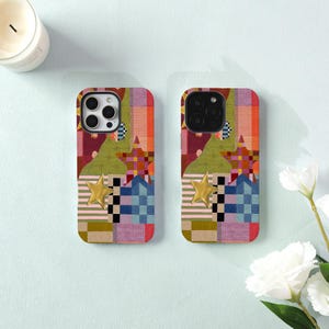 May include: Two identical smartphone cases featuring a patchwork design of various geometric shapes, stripes, and checkered patterns in shades of red, green, blue, and pink. Each case displays a prominent gold-colored star emblem on the front.