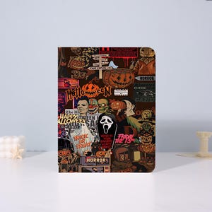 May include: A rectangular notebook cover featuring a collage of horror movie characters, pumpkins, and Halloween-themed imagery. The design includes text such as Halloween, Trick or Treat, Friday the 13th, and What is your favorite scary movie?