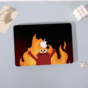 May include: A black laptop case featuring a cartoon character in flames with an Apple logo. The character is red with wide eyes and outstretched arms, set against a backdrop of orange and yellow flames.