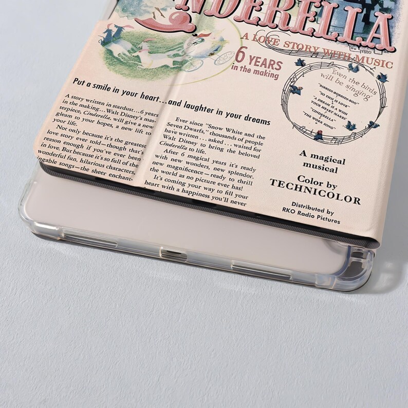 May include: A phone case featuring a vintage design for the movie "Cinderella." The case has a cream-colored background with text and illustrations. The text includes "A Love Story With Music" and "6 Years in the Making."
