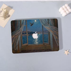 May include: Laptop skin featuring a painting of a nighttime cityscape viewed through an open window. The artwork depicts a moonlit sky, a bird in flight, and a body of water. A white Apple logo is centered on the skin.