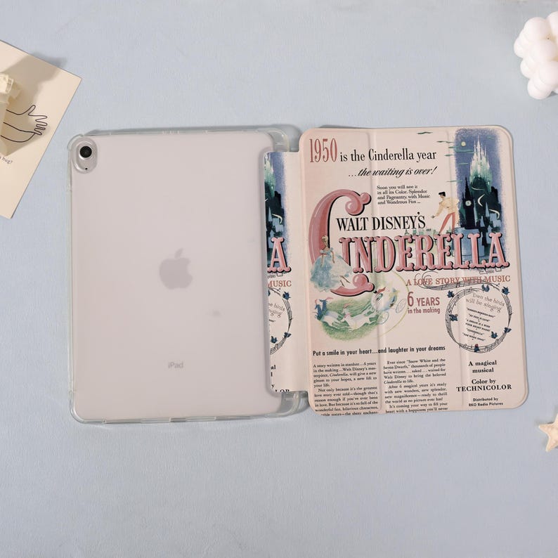 May include: Clear iPad case with a Disney Cinderella design. The case features the text "1950 is the Cinderella year" and "Walt Disney's Cinderella, A Love Story with Music". The design includes illustrations and the words "6 Years in the making".