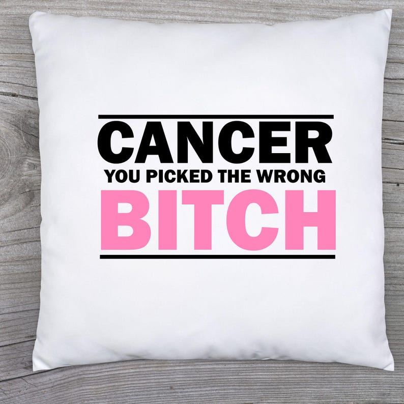 May include: A white square pillow with the text "CANCER YOU PICKED THE WRONG BITCH" in black and pink. The text is centered on the pillow, with the word "CANCER" at the top and "BITCH" at the bottom.