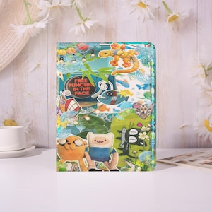 May include: A colorful, patterned case featuring cartoon characters and the text "FREE PUNCHES IN THE FACE." The design includes a lizard, fish, and other whimsical elements. The case is likely for a phone or tablet.