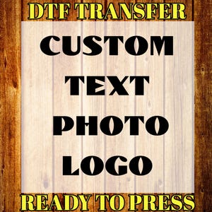 May include: A wooden background with the words "DTF TRANSFER" and "READY TO PRESS" in yellow. The words "CUSTOM TEXT PHOTO LOGO" are in large black letters.