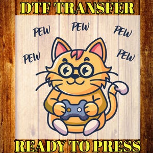 May include: DTF TRANSFER graphic featuring a cartoon cat wearing glasses and holding a video game controller. The cat is orange with black whiskers and is surrounded by the word "PEW". The text "READY TO PRESS" is also included.