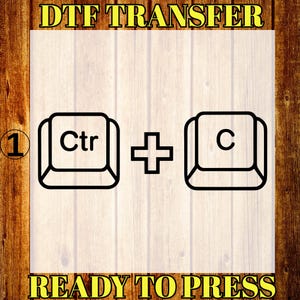 Puede incluir: Gráfico DTF TRANSFER con el texto "READY TO PRESS". La imagen muestra una ilustración en blanco y negro de las teclas "Ctrl" y "C" de un teclado, conectadas por un signo más, sobre un fondo de vetas de madera clara.