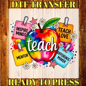 May include: A colorful DTF transfer design featuring a rainbow-colored apple with the word "teach" in the center. Surrounding the apple are colorful tags with the words "Inspire Minds", "Mentor", "Teach Love", and "Difference Maker". The design is decorated with daisies and stars.