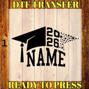 May include: Black graduation cap design with the year 2026 and the word "NAME" in bold letters. A cluster of stars forms a star shape. The text "DTF TRANSFER" and "READY TO PRESS" are in yellow.