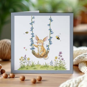 Tarjeta de felicitación universal cuadrada con conejito en un columpio de flores silvestres. Conejito, fauna silvestre y acuarela.