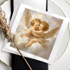 Może przedstawiać: Dekoracja stołu z białym talerzem o falistych krawędziach, czarną kopertą i kwadratową serwetką z ilustracją cherubina. Suszona łodyga rośliny dodaje naturalnego elementu do aranżacji.