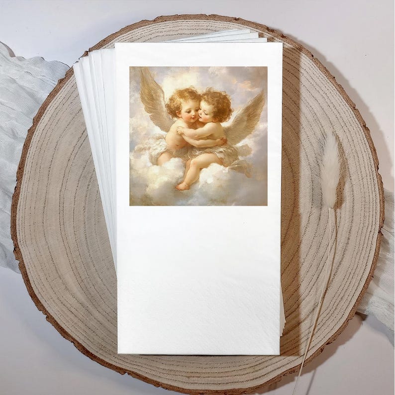 Może przedstawiać: Stos białych papierowych serwetek z nadrukowanym wizerunkiem dw&oacute;ch obejmujących się cherubin&oacute;w na chmurze. Serwetki są prezentowane na plastrze drewna z naturalną krawędzią i suszoną łodygą rośliny.