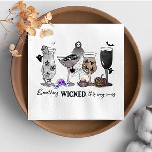 May include: A white square napkin with a Halloween-themed design. The illustration features various cocktail glasses with spooky elements, skulls, a grim reaper, and a jack-o'-lantern. The text "Something WICKED this way comes" is printed at the bottom.