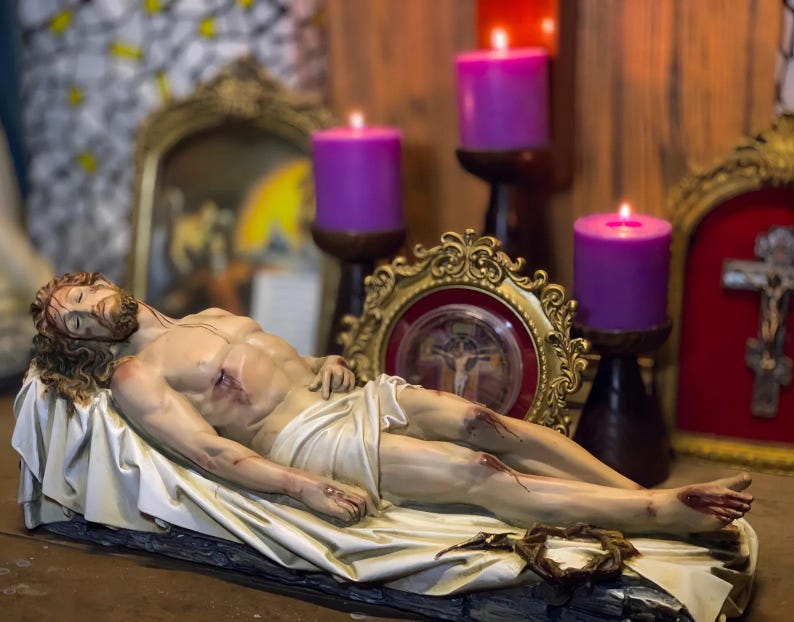 Peut inclure: Une sculpture d&eacute;taill&eacute;e d'une figure couch&eacute;e, repr&eacute;sentant un homme bless&eacute;, drap&eacute; dans un tissu blanc. La figure est entour&eacute;e de bougies violettes allum&eacute;es et de cadres dor&eacute;s orn&eacute;s, sugg&eacute;rant un th&egrave;me religieux. Une couronne d'&eacute;pines repose pr&egrave;s des pieds.
