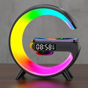 May include: A black, G-shaped desk lamp with a color-changing LED light. The lamp has a digital clock display and a wireless charging pad with a smartphone on top. The time displayed is 08:58 AM.