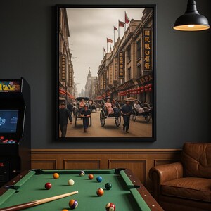 Puede incluir: Una impresión enmarcada que representa una escena callejera vintage con rickshaws, peatones y edificios con caracteres chinos. La obra de arte está en tonos sepia, con banderas y faroles rojos. La imagen está encima de una mesa de billar verde.