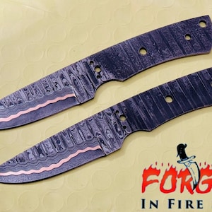 May include: Two forged steel knife blades with a patterned design and copper-colored accents. The blades have a pointed tip and several holes for handle attachment. The image includes the text "FORGED IN FIRE STEEL".