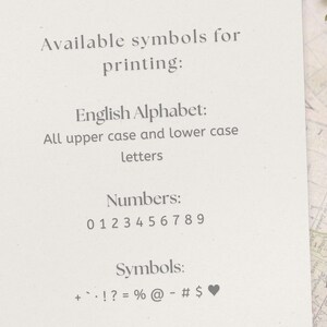Peut inclure: Une carte blanche avec du texte &eacute;num&eacute;rant les symboles disponibles pour l'impression, y compris l'alphabet anglais, les chiffres 0-9 et des symboles tels que +, -, !, ?, =, %, @, -, #, $, et un c&oelig;ur.