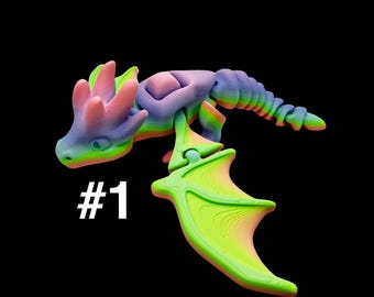 Peut inclure: Figurine de dragon imprimée en 3D aux couleurs de l'arc-en-ciel. Le dragon présente un design détaillé avec des ailes et une queue, ainsi que le numéro "#1" en blanc. La palette de couleurs comprend des nuances de bleu, vert, rose et jaune.