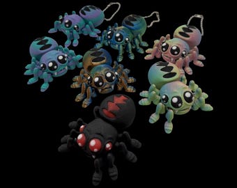 Peut inclure: Plusieurs figurines de petites araignées colorées, avec de grands yeux et des porte-clés. Les araignées sont de différentes couleurs, notamment bleu, vert, rose et noir, avec des motifs détaillés. Le fond est noir.
