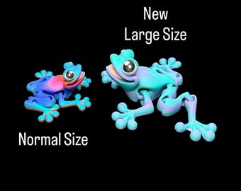 Peut inclure: Deux figurines de grenouilles colorées, l'une étiquetée "Normal Size" et l'autre "New Large Size". Les grenouilles sont principalement bleues, roses et violettes, avec de grands yeux expressifs. Le fond est noir.