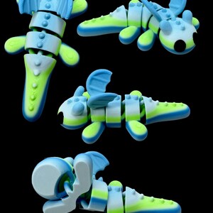 Op de afbeelding: Een verzameling gearticuleerde draakspeelgoed in verschillende poses. De draken zijn gesegmenteerd en hebben een kleurenschema van blauw, wit en neon groen. Elke draak heeft vleugels en een uniek ontwerp, met een zwarte achtergrond.