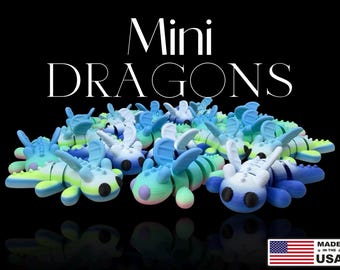 Peut inclure: Plusieurs figurines de mini-dragons colorés en bleu, vert et blanc, avec le texte "Mini Dragons" en blanc. Les figurines sont sur fond noir. Fabriqué aux États-Unis.
