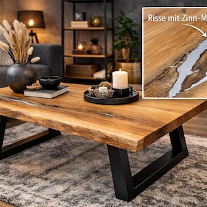 Könnte beinhalten: Rechteckiger Couchtisch aus Holz mit natürlicher Kante und schwarzen Metallbeinen. Die Tischplatte hat eine warme braune Farbe, mit einer Nahaufnahme, die eine silberfarbene Einlage zeigt. Eine Kerze und Dekorationsartikel stehen oben.