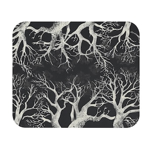 May include: A rectangular, rounded-corner mat featuring a repeating pattern of white tree branches against a dark gray background. The branches are detailed and textured, creating a stark contrast with the background. The overall design has a gothic or spooky aesthetic.