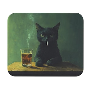 May include: A square mousepad featuring a black cat with a cigarette in its mouth, sitting at a wooden table. A glass of amber liquid sits to the left of the cat. Smoke rises from the cigarette against a green background.